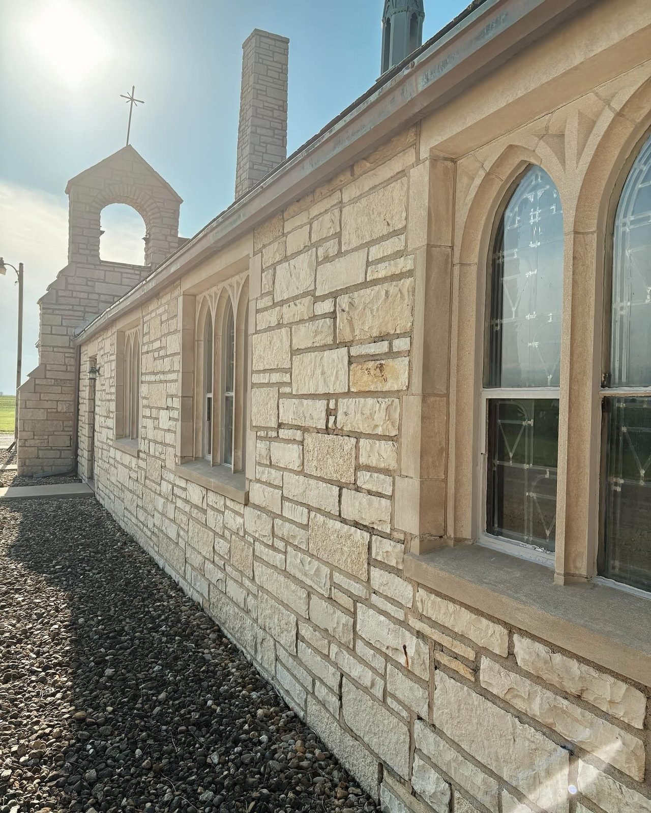 The stone side wall of the church with arched windows