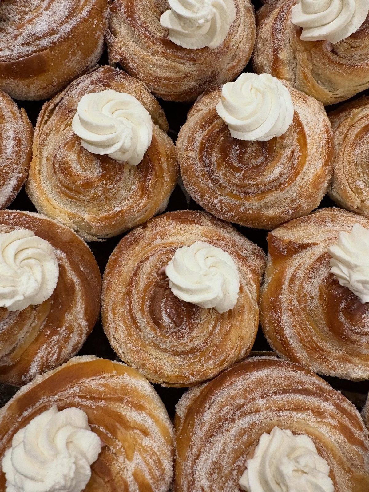Fresh cinnamon rolls with a swirl of cream