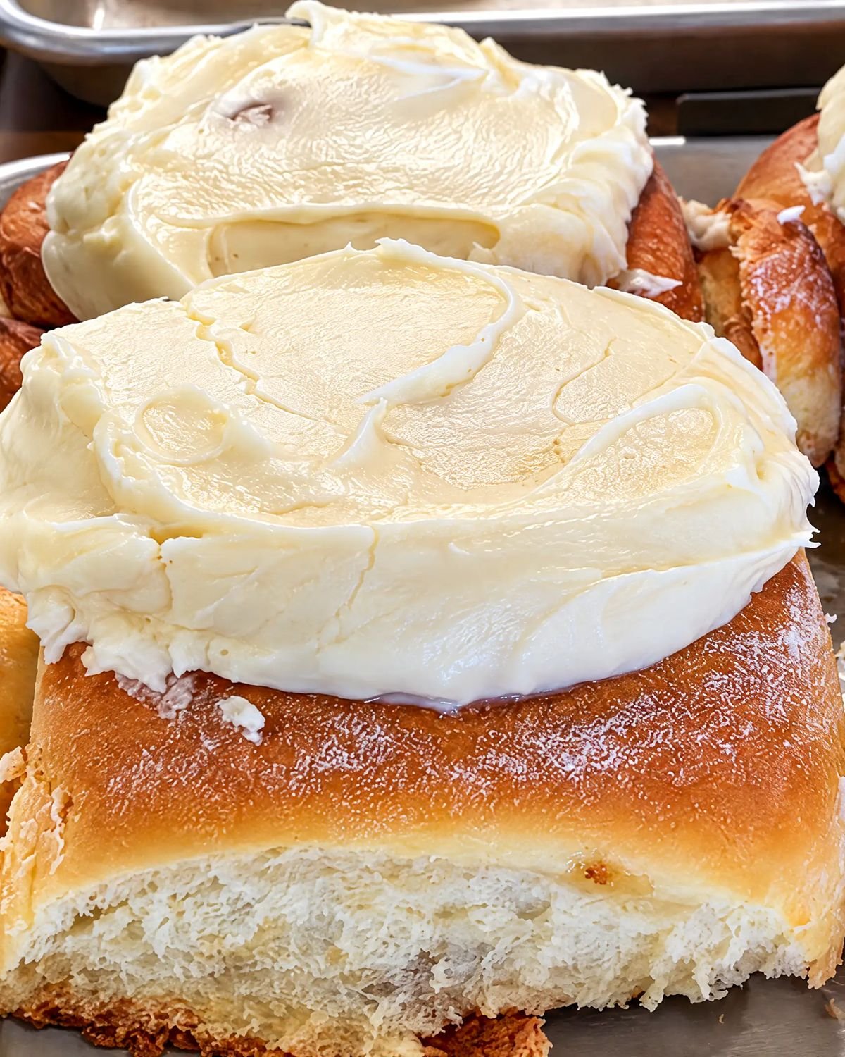 Soft sweet rolls topped with a thick layer of white frosting